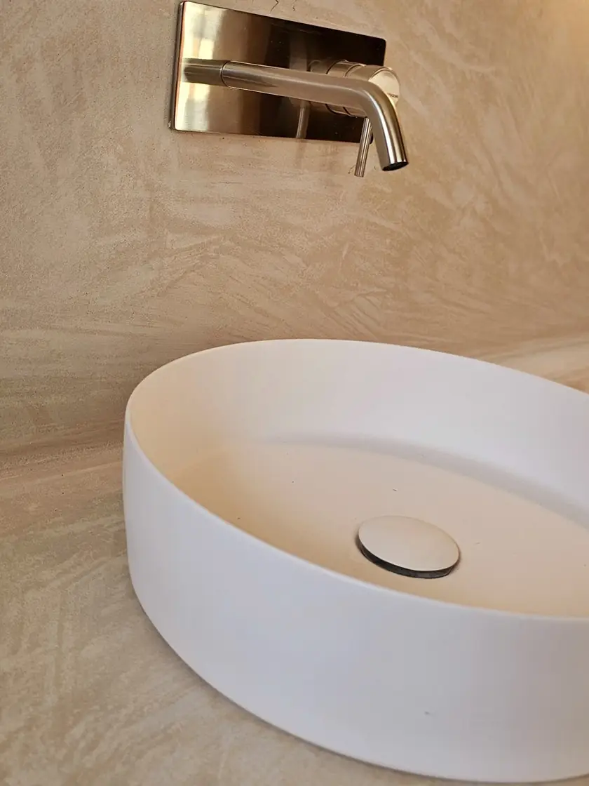 Lavabo sobre encimera y mueble de micromortero con grifería empotrada
