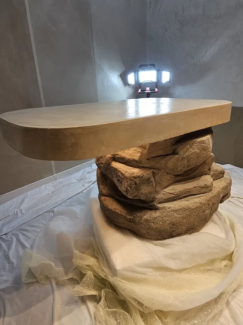 Mesa con base de roca modelada a mano y tapa curva de micromortero